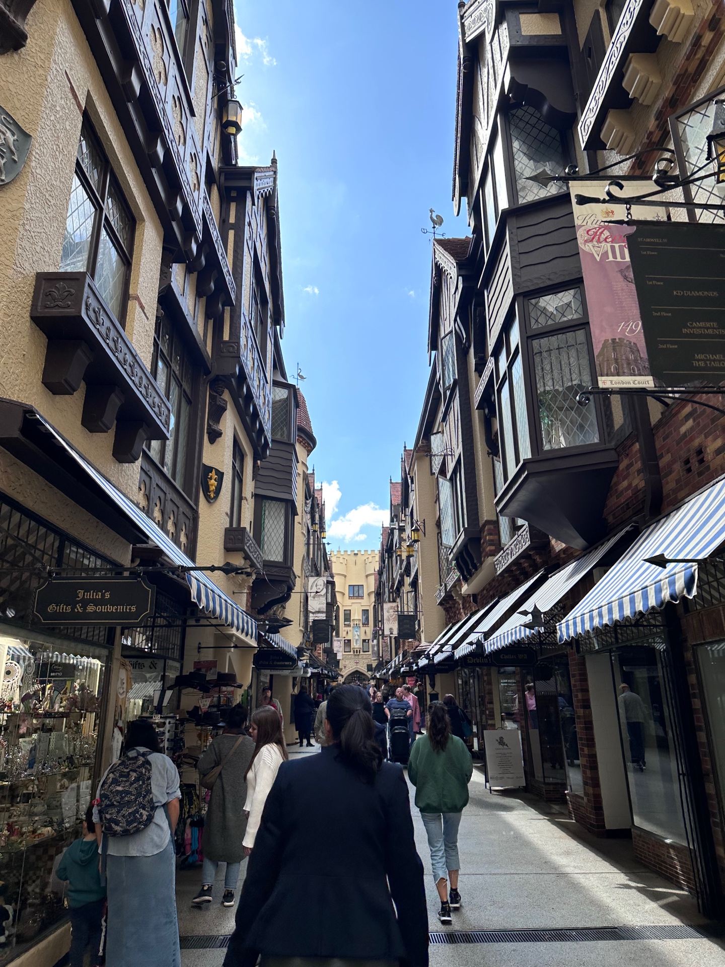 Shoppers walking through London Court arcade with Tudor-style shopfronts